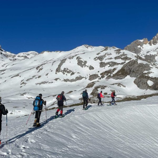 Seis personas subiendo por una pista de nieve con raquetas de nieve - fotopicos.com