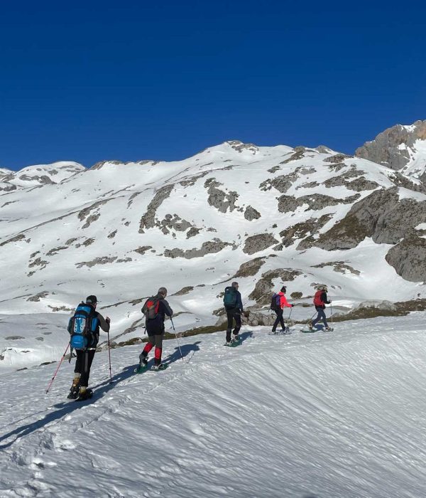 Seis personas subiendo por una pista de nieve con raquetas de nieve - fotopicos.com