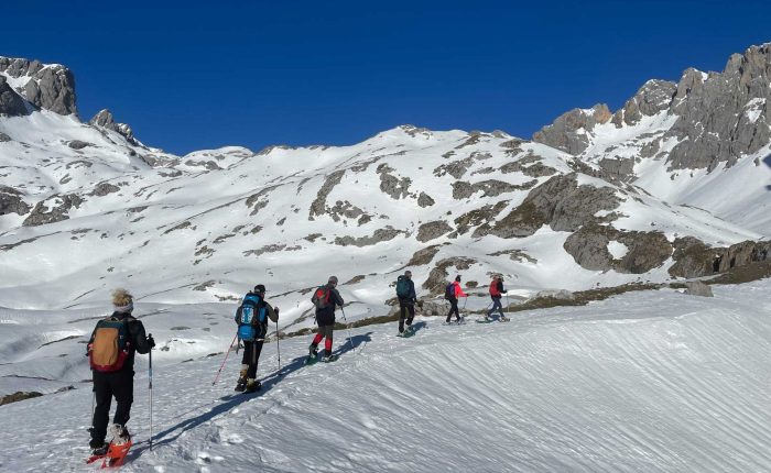 Seis personas subiendo por una pista de nieve con raquetas de nieve - fotopicos.com