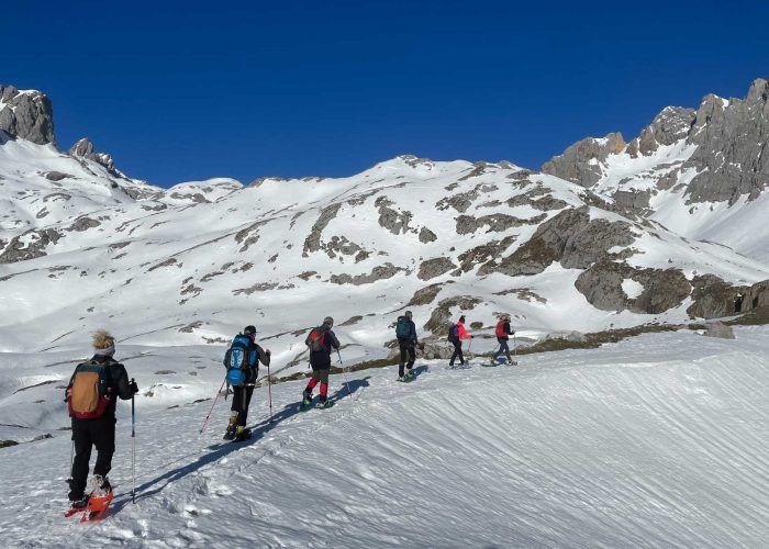 Seis personas subiendo por una pista de nieve con raquetas de nieve - fotopicos.com