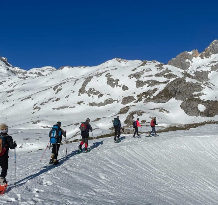 Seis personas subiendo por una pista de nieve con raquetas de nieve - fotopicos.com