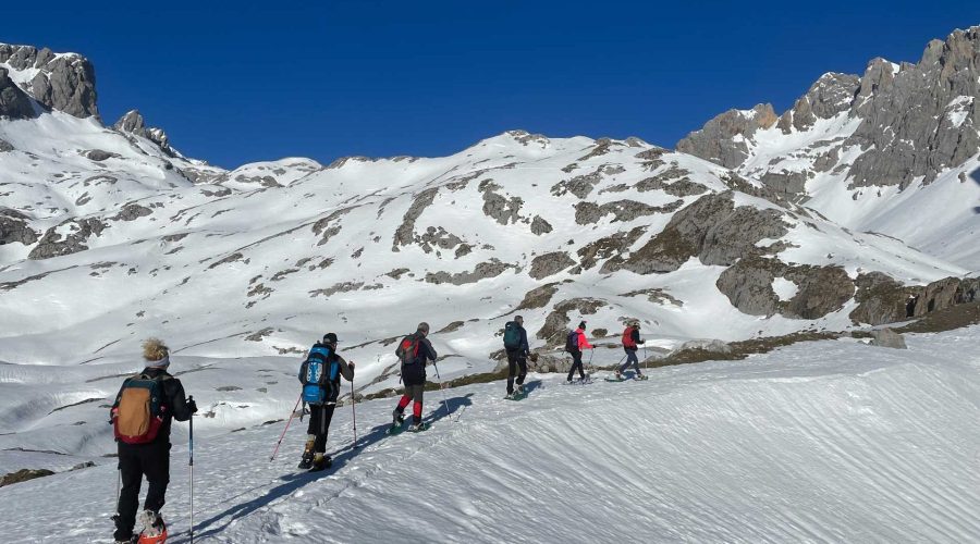 Seis personas subiendo por una pista de nieve con raquetas de nieve - fotopicos.com